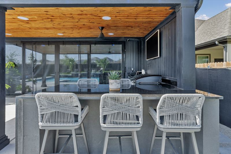 Poolside bar with rope stools under a cedar ceiling